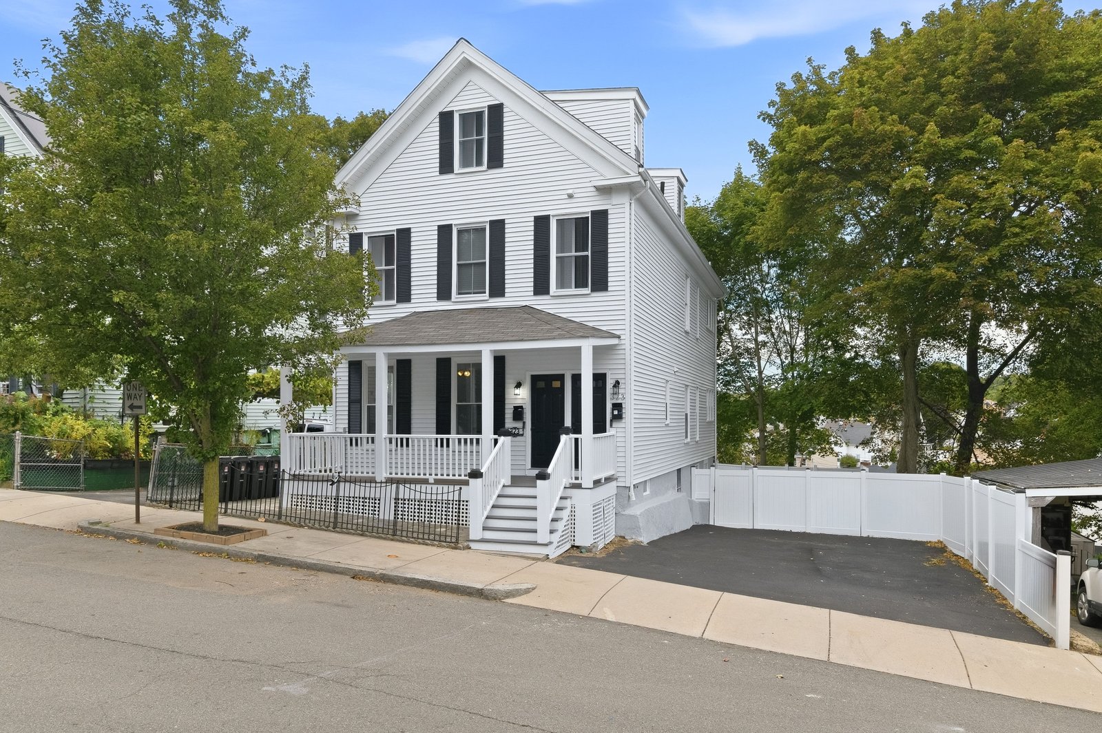 Front exterior of 323 Bainbridge Street, a white two family home in Malden